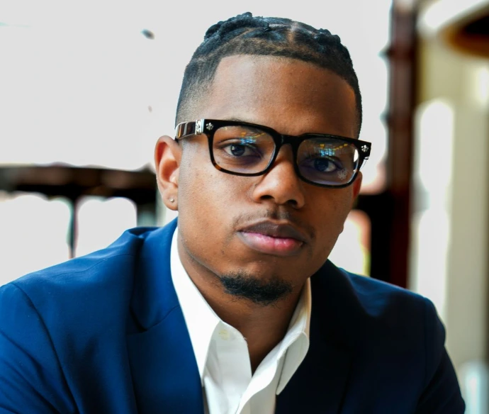 A man in a suit and glasses sitting down